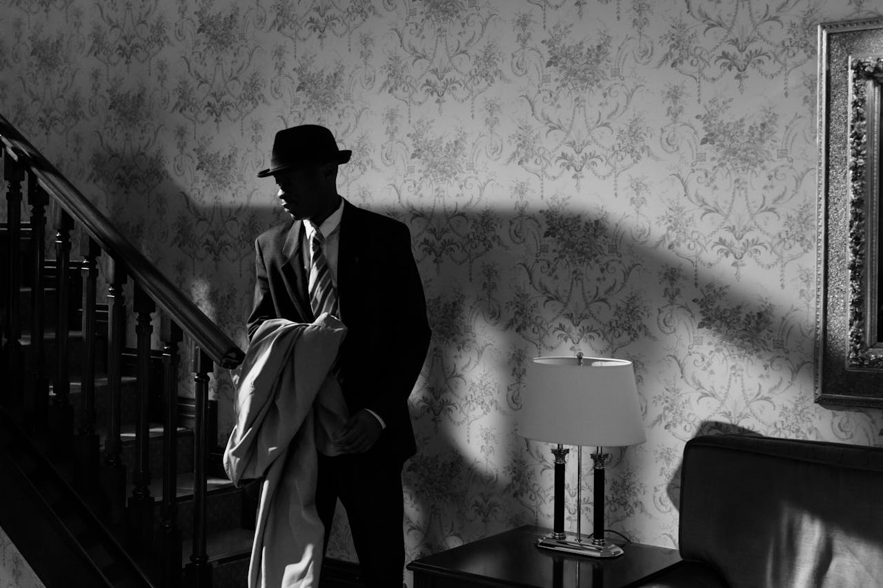 Home A black and white scene of a detective in a vintage interior, exuding mystery and intrigue.